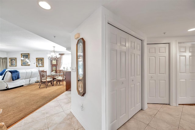 hall with light carpet, light tile patterned floors, a chandelier, and recessed lighting