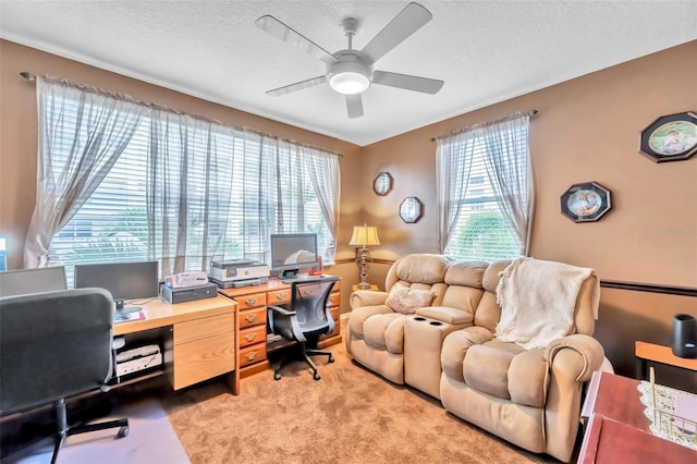 carpeted home office featuring plenty of natural light, a textured ceiling, and ceiling fan