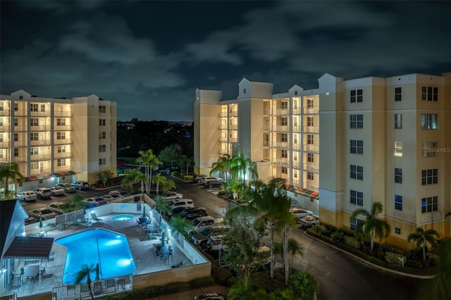 property at twilight featuring a community pool