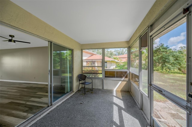 unfurnished sunroom with ceiling fan