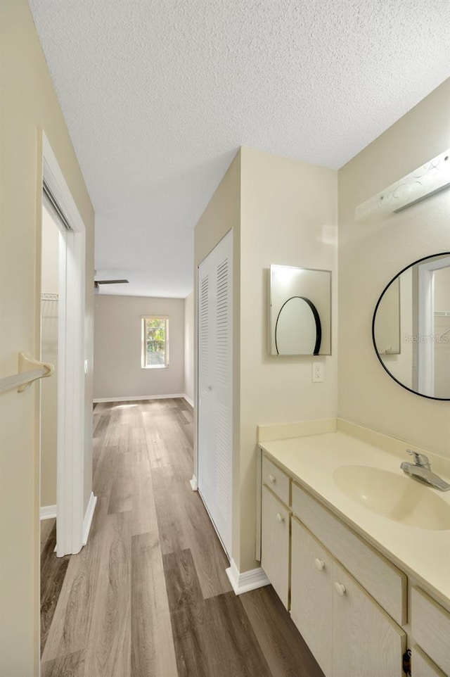 bathroom with vanity, wood-type flooring, and a textured ceiling