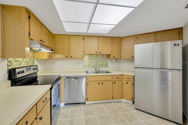 kitchen with stainless steel appliances, light tile patterned flooring, sink, and decorative backsplash