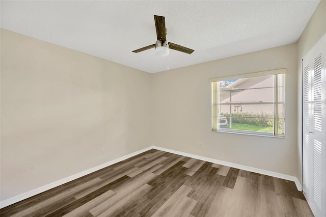 empty room featuring hardwood / wood-style floors, ceiling fan, and a textured ceiling