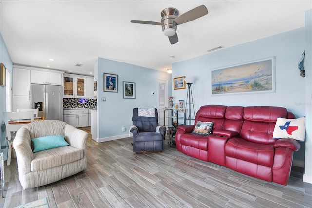 living room with ceiling fan and light wood-type flooring