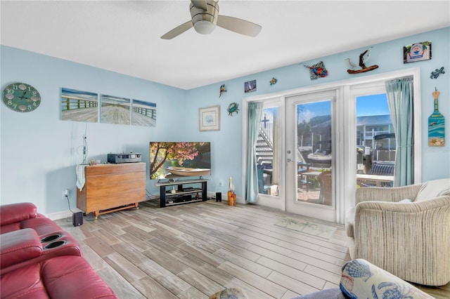 living room with ceiling fan and light wood-type flooring