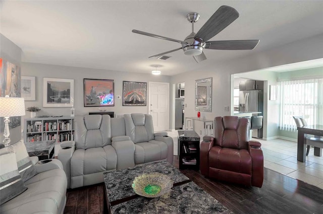 living room with dark hardwood / wood-style flooring and ceiling fan