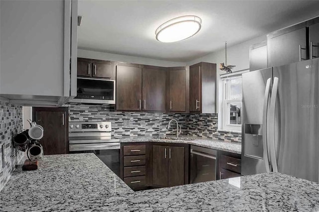 kitchen with sink, dark brown cabinets, backsplash, stainless steel appliances, and light stone countertops