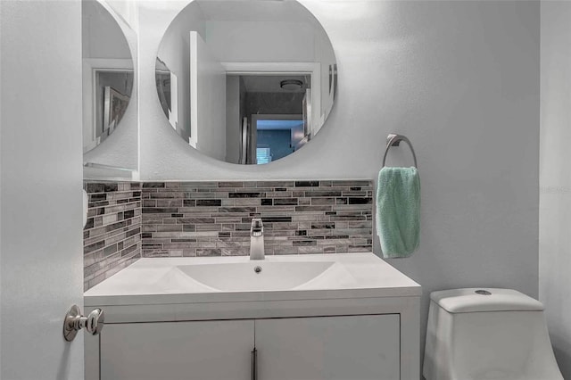 bathroom featuring toilet, tasteful backsplash, and vanity