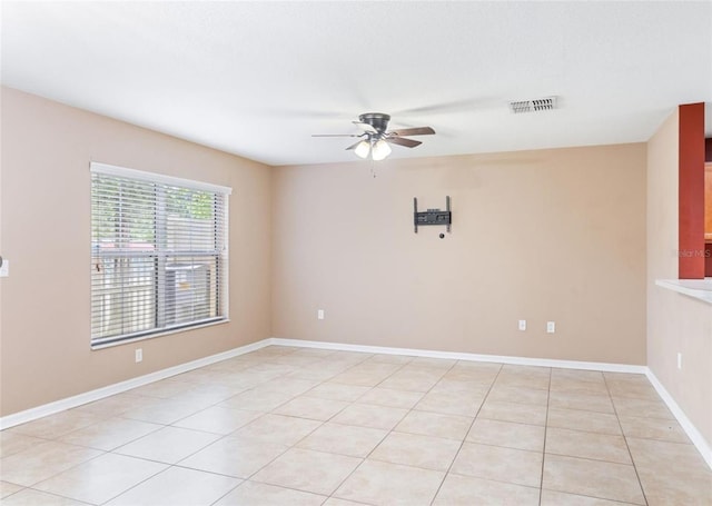 spare room with ceiling fan and light tile flooring