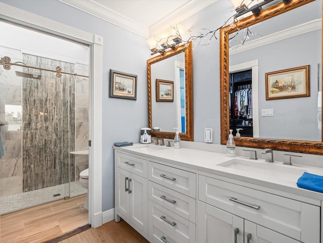 bathroom with walk in shower, hardwood / wood-style floors, ornamental molding, vanity, and toilet