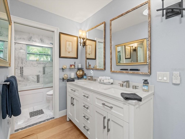 full bathroom with enclosed tub / shower combo, vanity, toilet, and hardwood / wood-style flooring