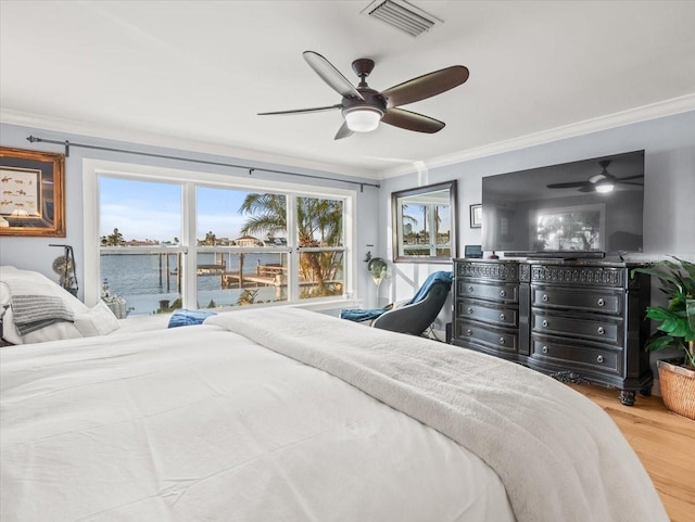 bedroom featuring ceiling fan, light hardwood / wood-style floors, and ornamental molding