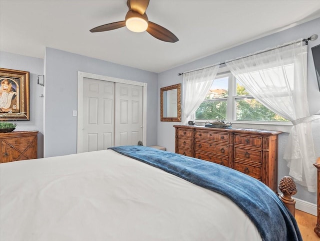 bedroom featuring ceiling fan, a closet, and light hardwood / wood-style floors