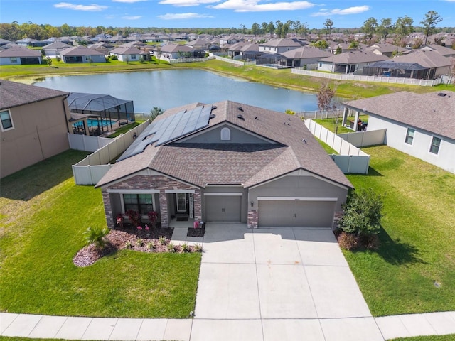 view of front facade featuring a garage, a front yard, and a water view