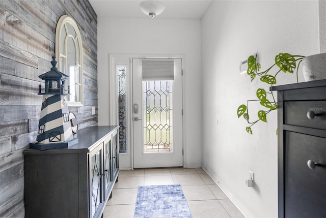 foyer entrance with light tile patterned floors and baseboards