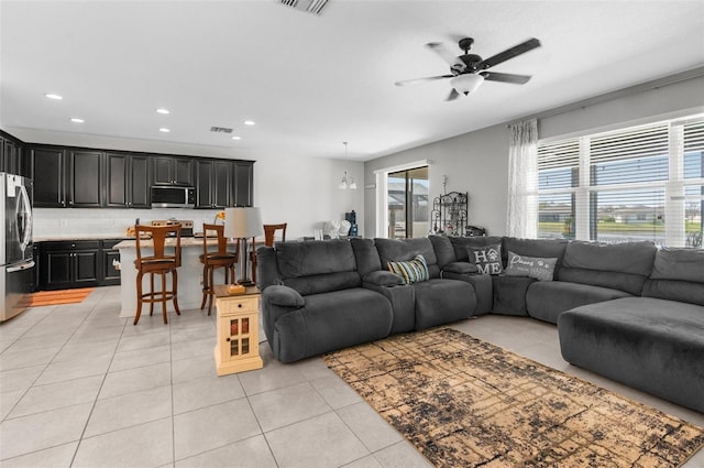 living area featuring light tile patterned floors, ceiling fan, visible vents, and recessed lighting