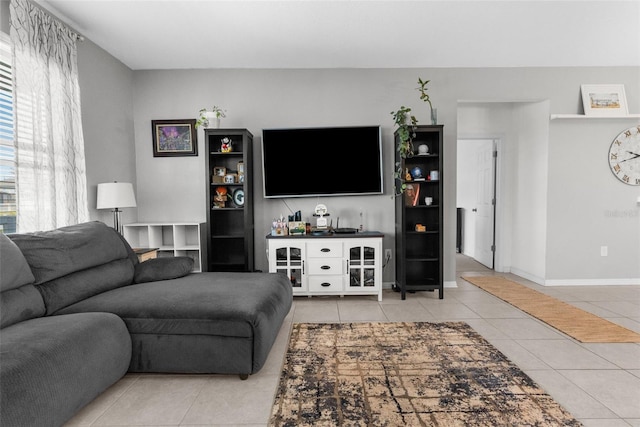 tiled living area featuring baseboards and a bar