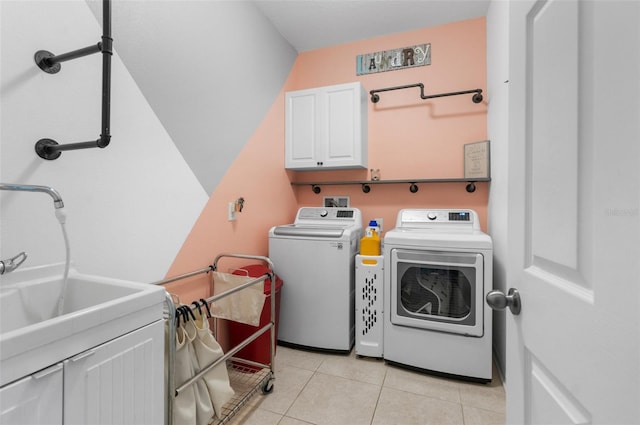 clothes washing area with cabinet space, washer and clothes dryer, a sink, and light tile patterned flooring