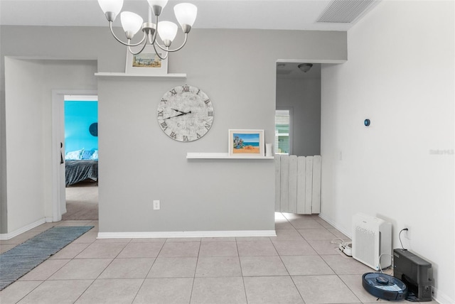 unfurnished dining area with a chandelier, tile patterned flooring, visible vents, and baseboards