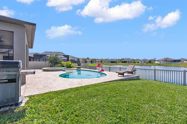 view of swimming pool with a lawn, a fenced backyard, a water view, a patio area, and a pool with connected hot tub