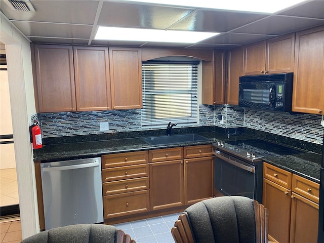 kitchen featuring backsplash, dark stone countertops, sink, and stainless steel appliances