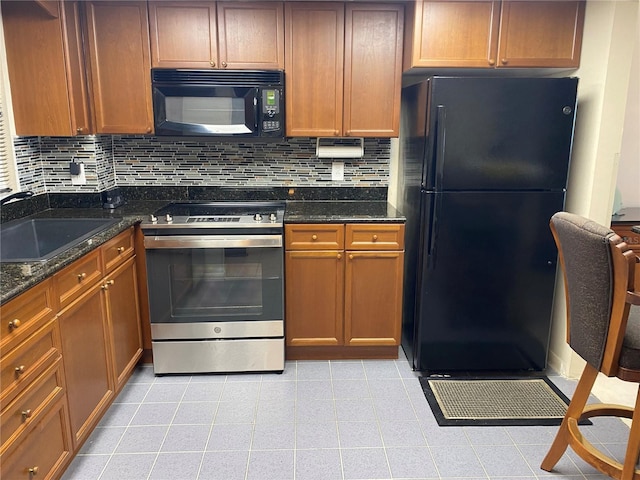 kitchen featuring backsplash, dark stone counters, sink, black appliances, and light tile patterned flooring