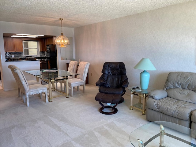 living room with light colored carpet, a chandelier, and a textured ceiling