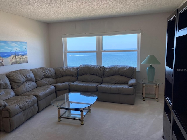 carpeted living room featuring a textured ceiling, a water view, and plenty of natural light