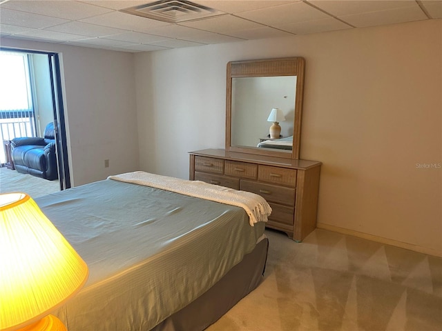 bedroom with a paneled ceiling and light carpet