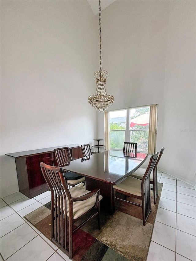 tiled dining space featuring high vaulted ceiling and an inviting chandelier