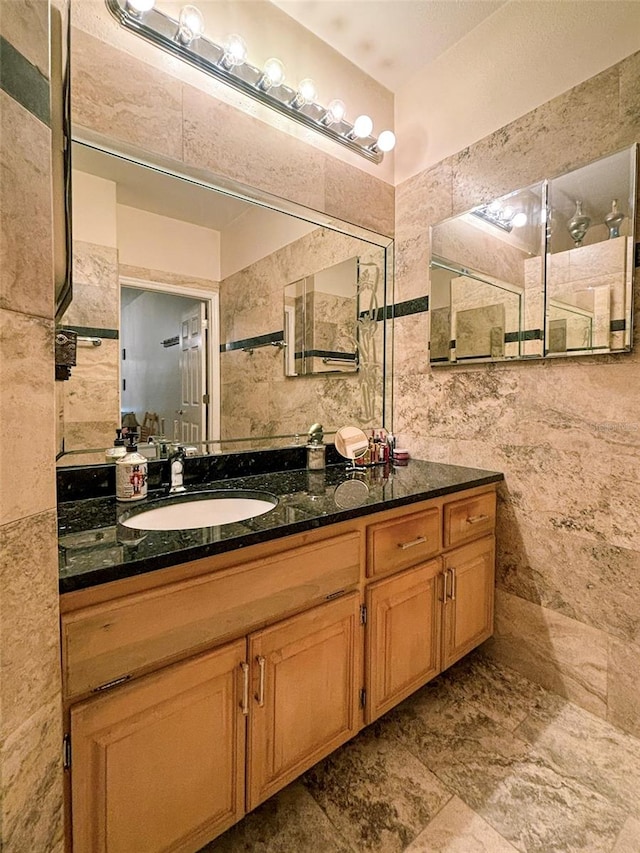 bathroom featuring tile walls, vanity, and tile flooring