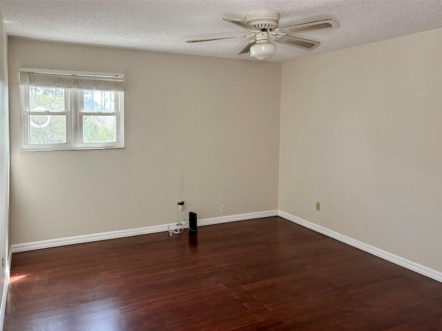 empty room featuring a textured ceiling, ceiling fan, and dark wood-type flooring