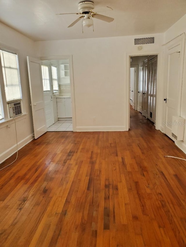 unfurnished room with ceiling fan, cooling unit, and light hardwood / wood-style floors