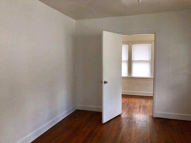 empty room with dark wood-type flooring