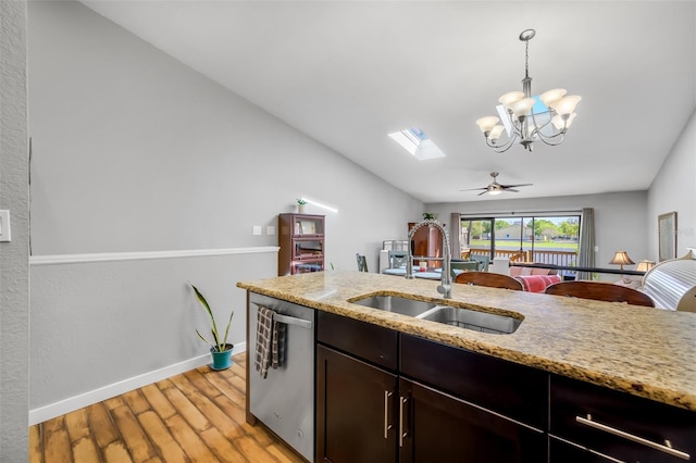 kitchen featuring pendant lighting, ceiling fan with notable chandelier, sink, stainless steel dishwasher, and a skylight