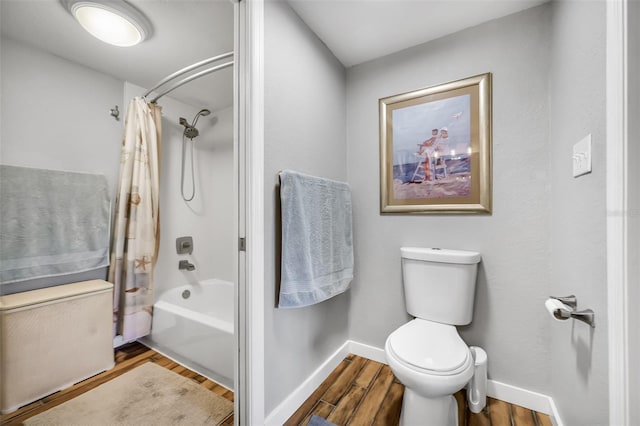 bathroom featuring hardwood / wood-style floors, toilet, and shower / bathtub combination with curtain