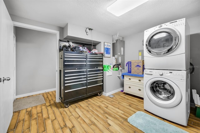 laundry room with water heater, light hardwood / wood-style floors, and stacked washer / dryer