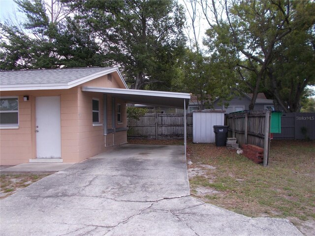 view of home's exterior featuring a storage shed and a carport