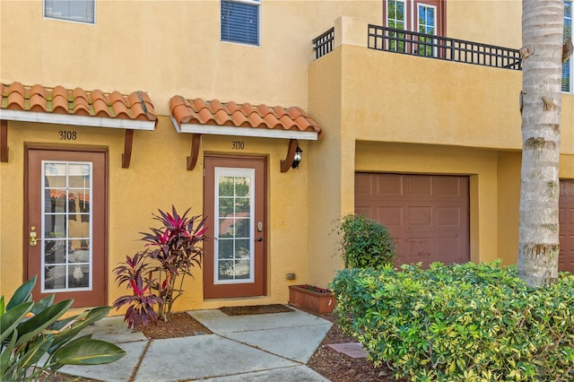 doorway to property with a garage and a balcony