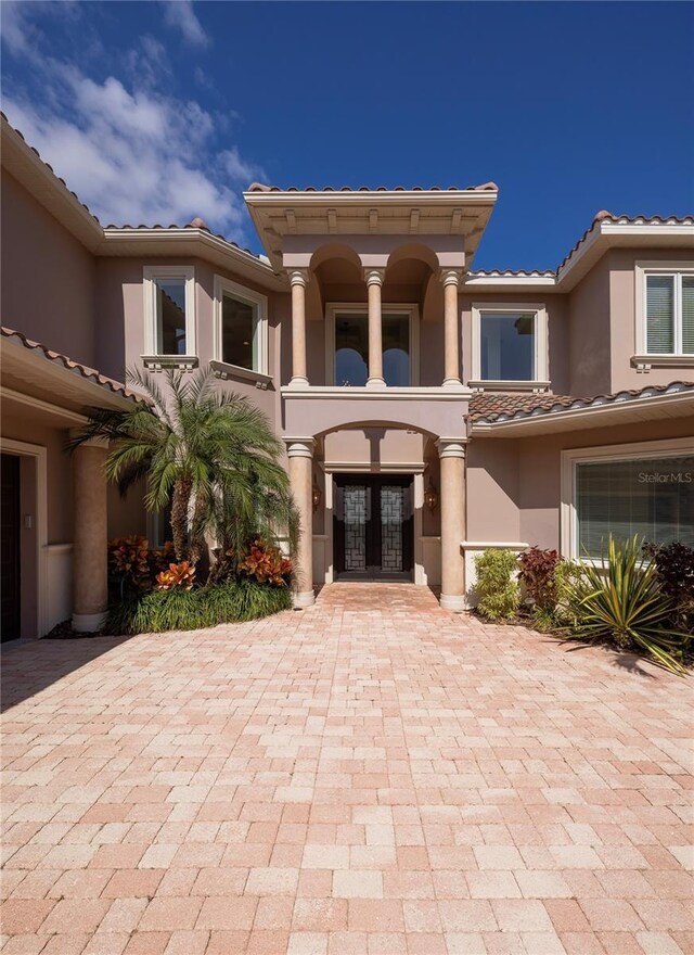 898 Skye Ln, Palm Harbor, FL 34683 - view of front of home featuring french doors, a tile roof, and stucco siding