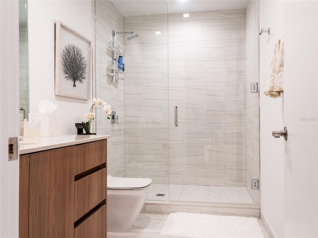 bathroom featuring toilet, a shower with shower door, and vanity