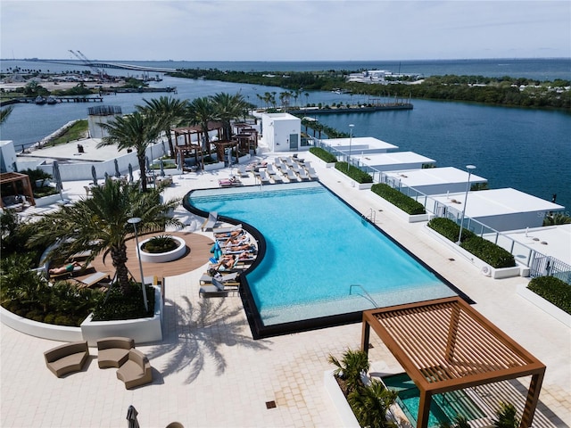 view of pool with a patio area and a water view