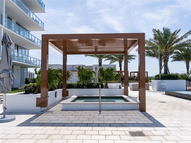 surrounding community featuring a jacuzzi and a pergola