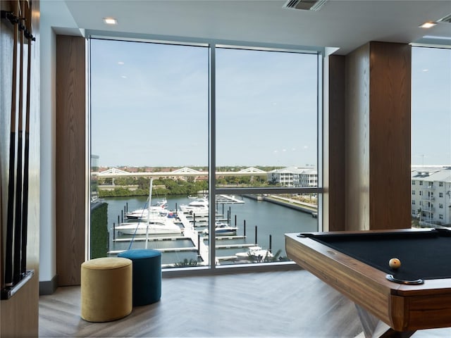 game room featuring billiards, expansive windows, and a water view