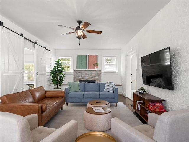 living room featuring a barn door and ceiling fan