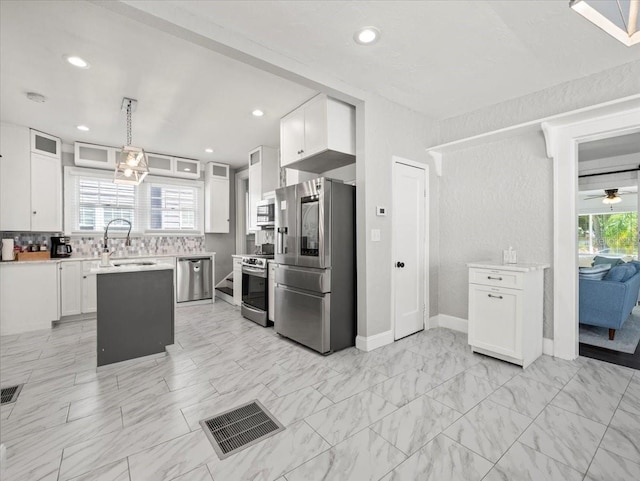 kitchen featuring light tile floors, white cabinets, ceiling fan, and stainless steel appliances