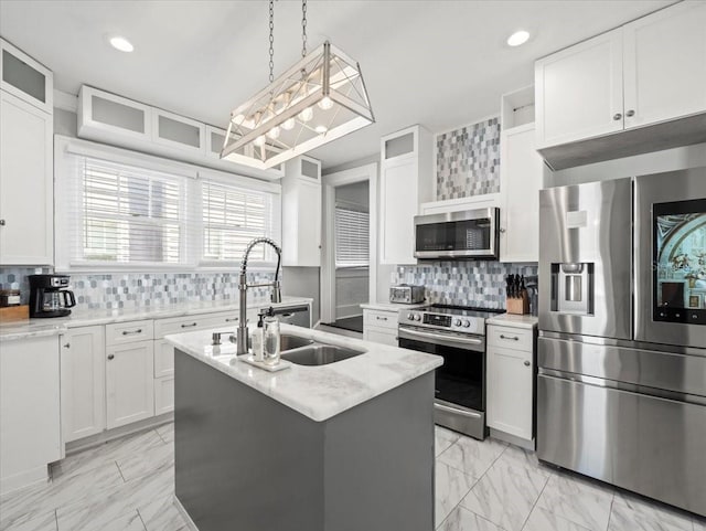 kitchen with backsplash, a center island with sink, stainless steel appliances, and light tile floors