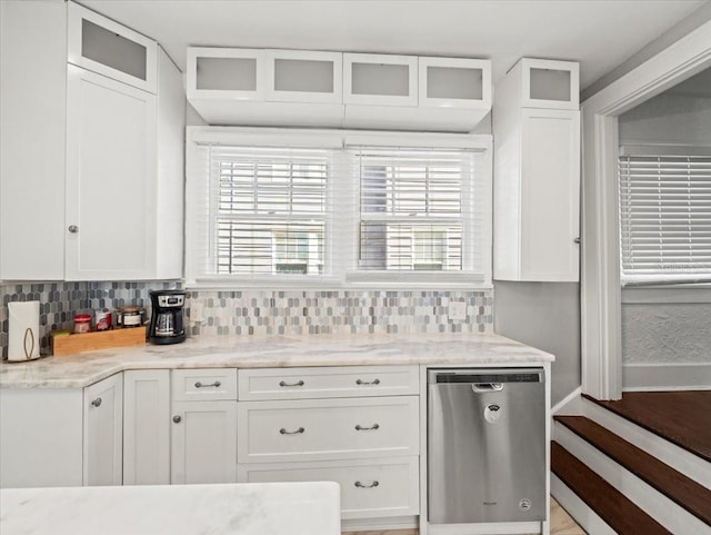 kitchen featuring white cabinets, tasteful backsplash, dishwasher, and light stone counters