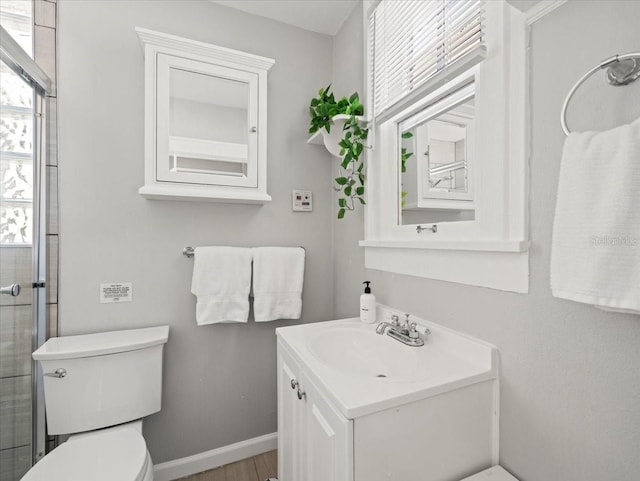 bathroom with toilet, vanity, and hardwood / wood-style floors