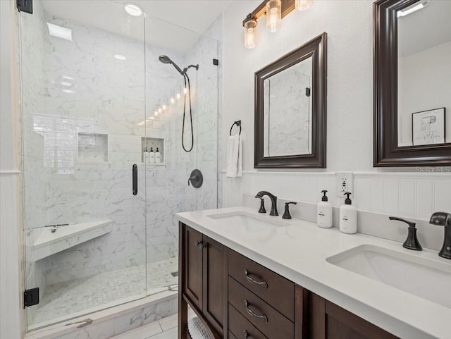 bathroom with tile flooring, a shower with shower door, and dual bowl vanity